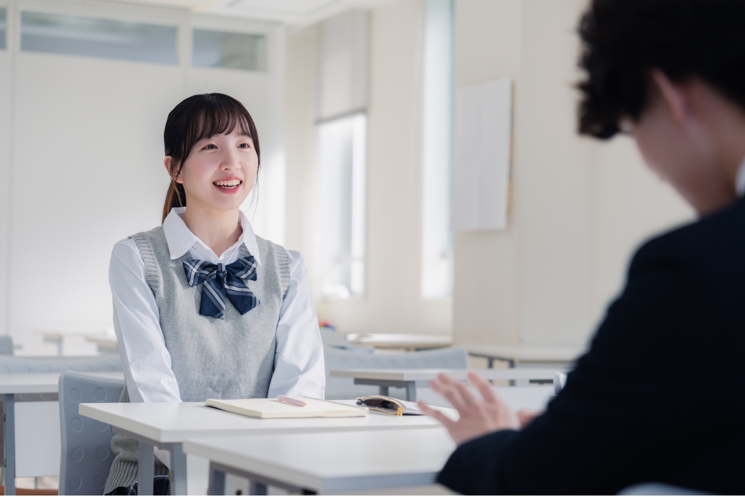 教室で学習について話す生徒